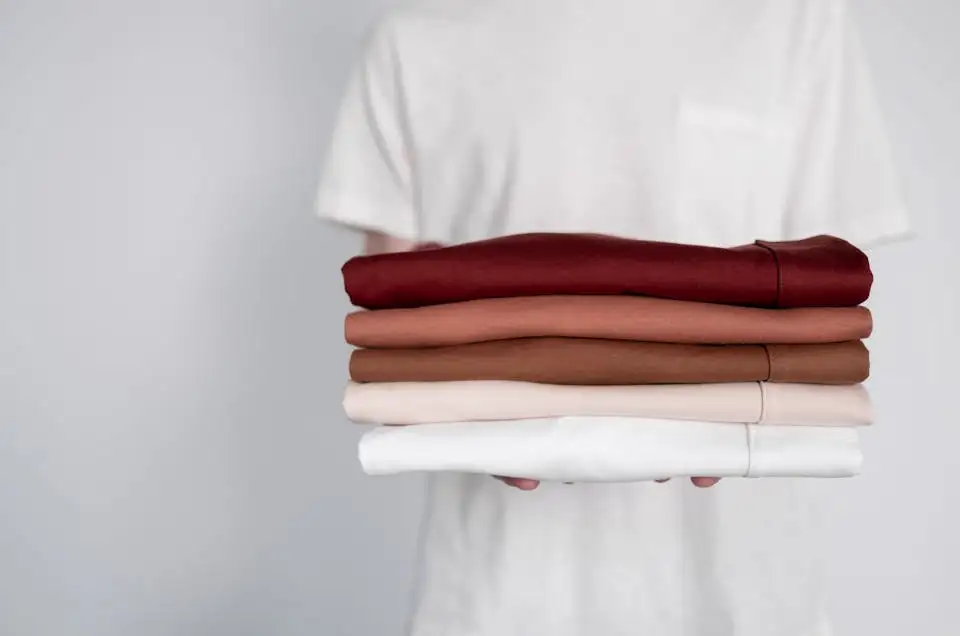 holding clean folded shirts